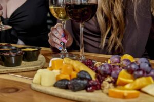 Woman's hand holding a glass of wine and enjoying snacks