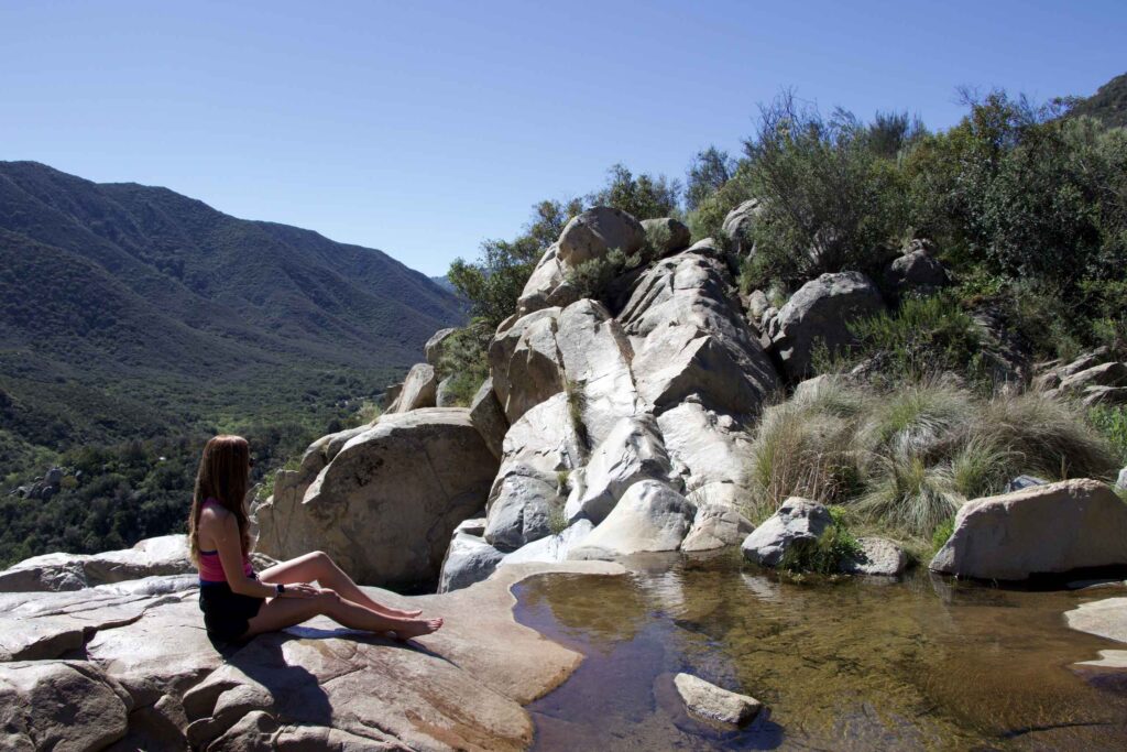 Woman sitting on rocks after a hike.