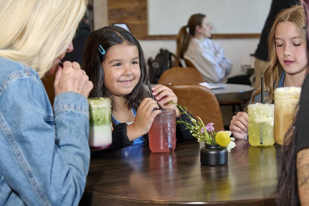 two kids sitting with their parents at a diner
