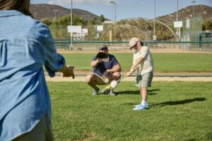 kid playing baseball with his parents in Murrieta